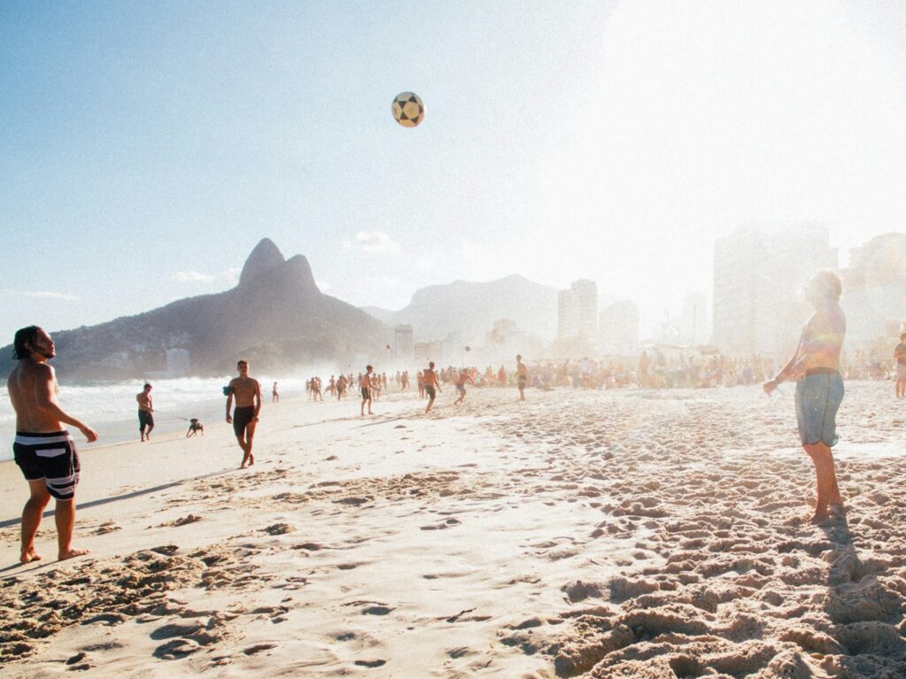 Foto da orla de Ipanema, pessoas jogando bola na areia da praia