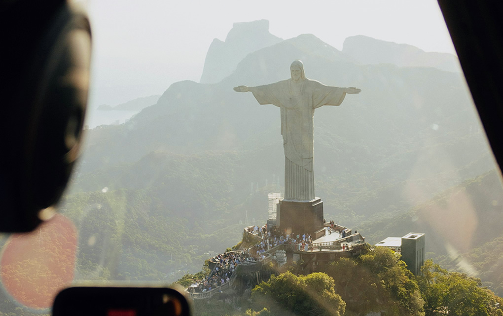 Pessoa em voo panorâmico com celular tirando foro do Cristo Redentor.