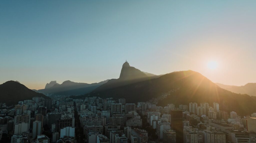 Cidade do Rio e Cristo Redentor visto de longe. Sol iluminando o Corcovado.