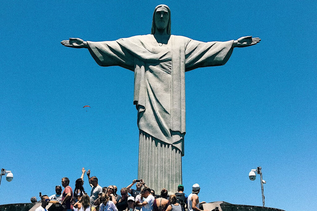 Pessoas tirando foto aos pés do Cristo no Rio de Janeiro